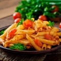 makaron-penne-w-sosie-pomidorowym-z-kurczakiem-i-pomidorami-na-drewnianym-stole (1)